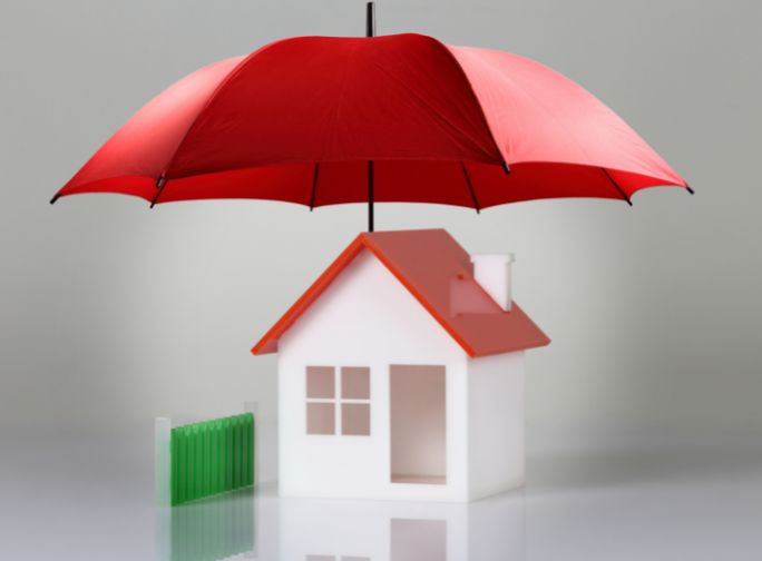 scale model of a house being protected by a red umbrella